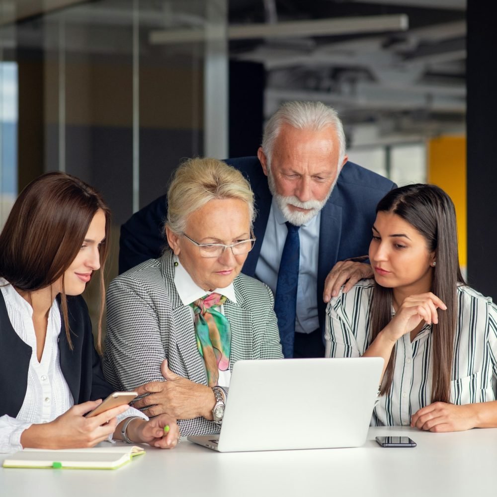 Mature businessman leader mentor talking to diverse colleagues team listening to caucasian ceo.